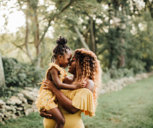 Mother holds her daughter in a garden setting