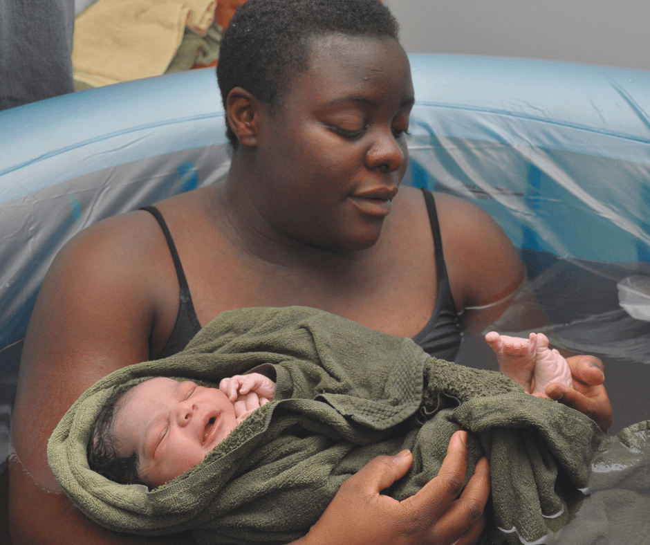 newborn baby is held after a water birth